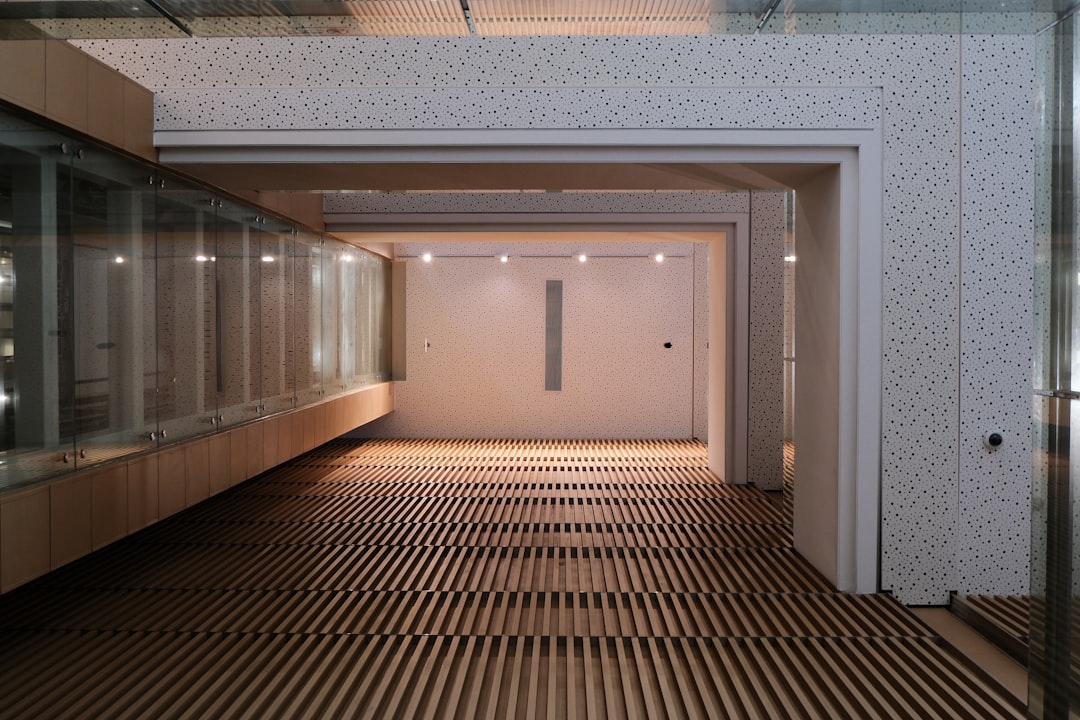 A modern hallway with slatted wooden floor and white walls.