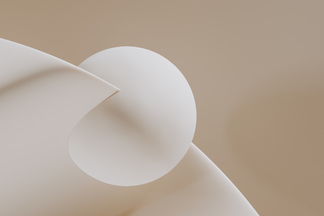 Abstract composition of curved white paper and sphere.